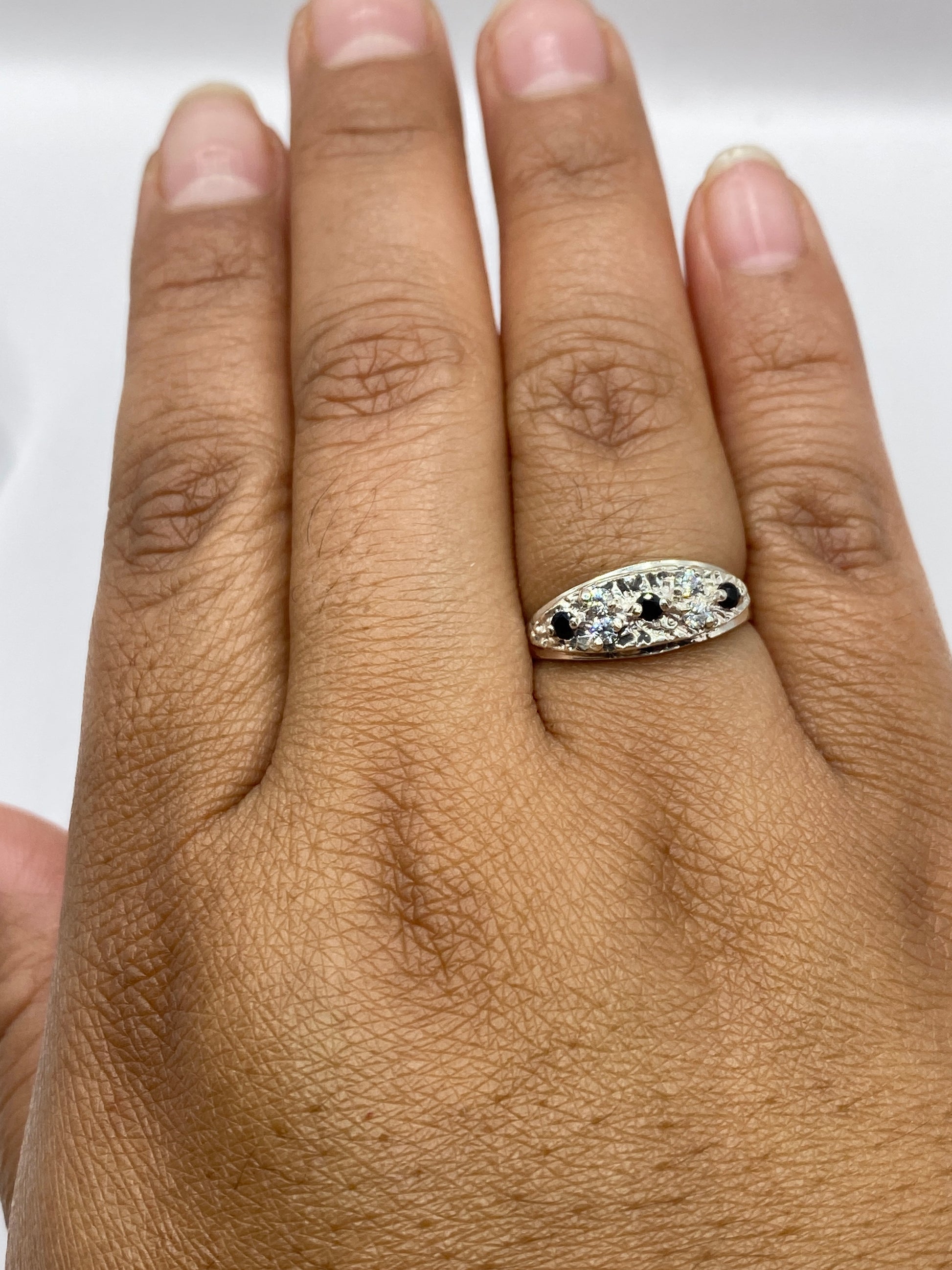 Anillo solitario en mano de mujer mostrando el sello 925 MEXICO