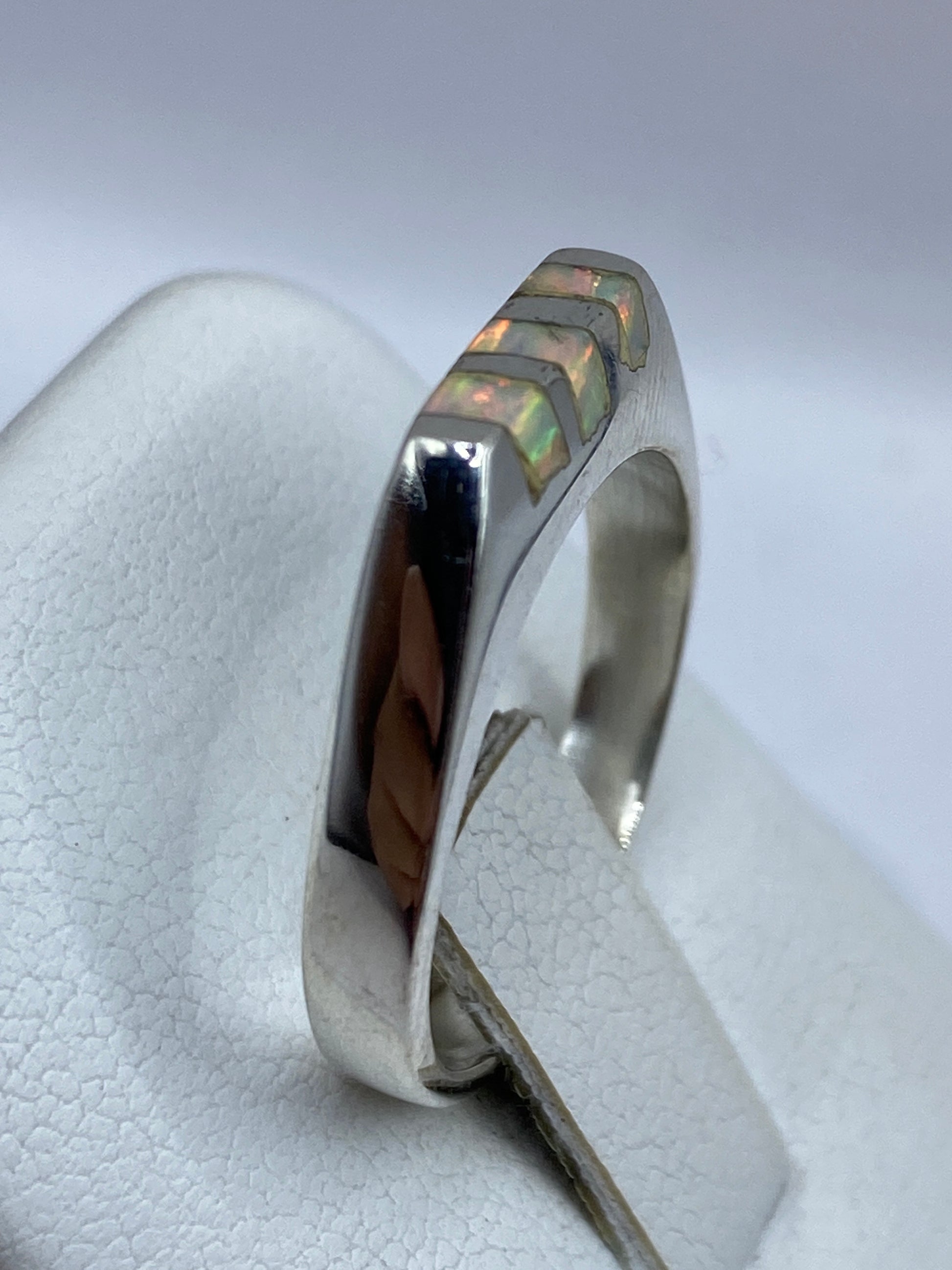 Anillo en dedo de mujer mostrando el brillo iridiscente del ópalo bajo la luz natural