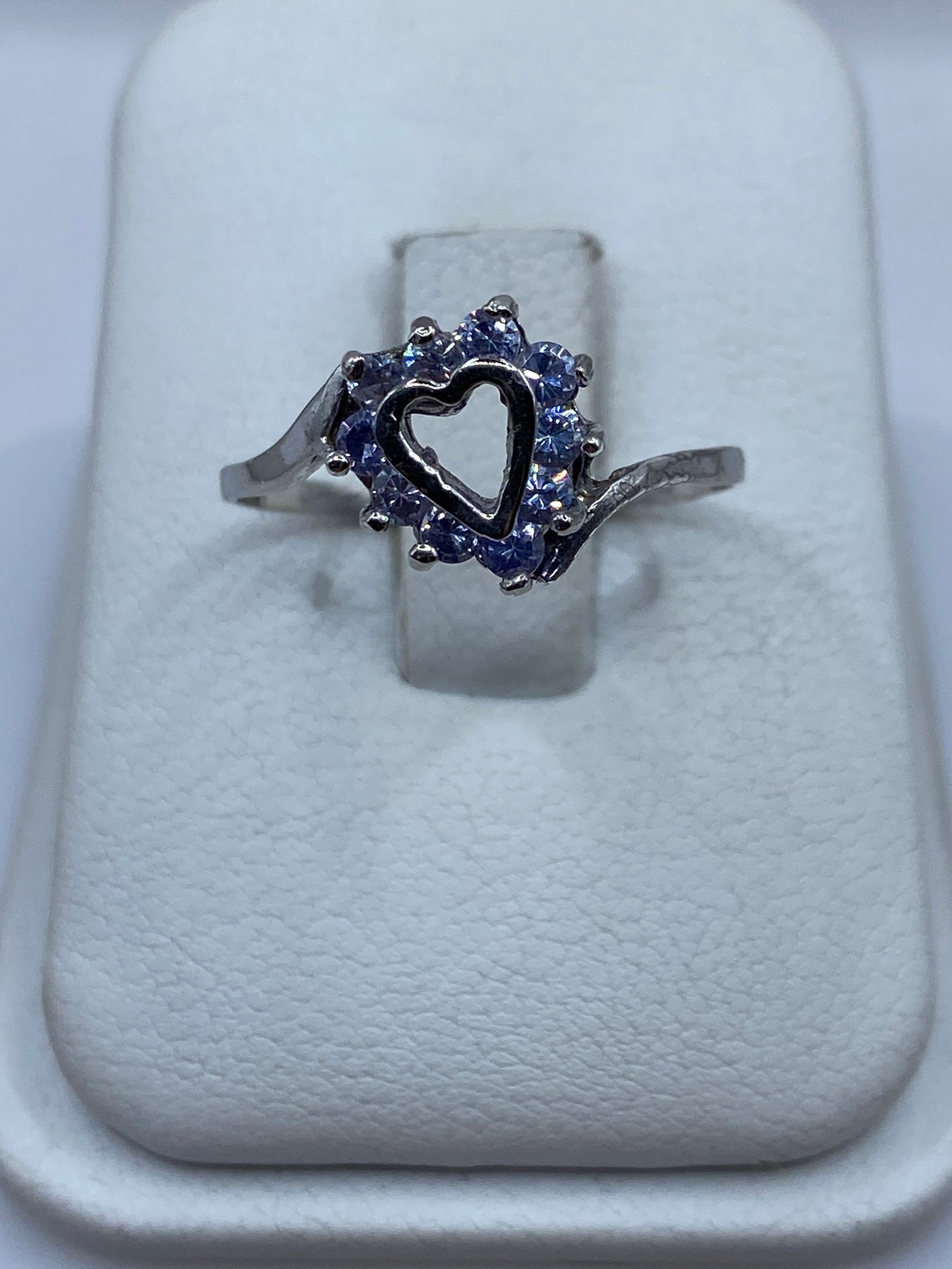 Anillo de plata solitario con circonia morada en halo sobre cojín blanco
