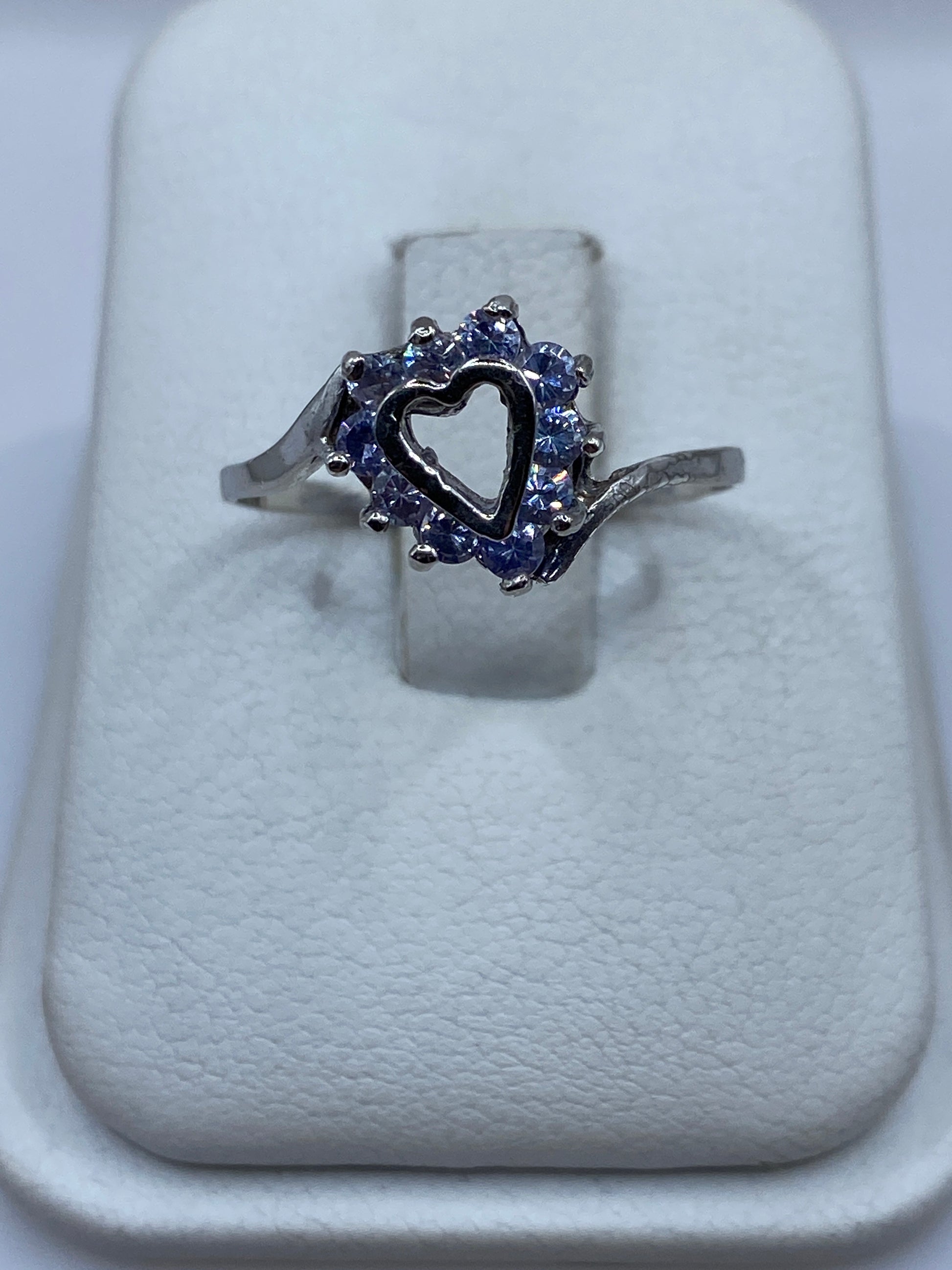 Anillo de plata solitario con circonia morada en halo sobre cojín blanco