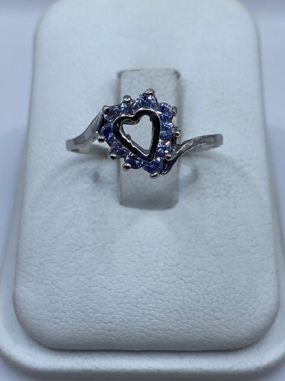 Anillo de plata solitario con circonia morada en halo sobre cojín blanco