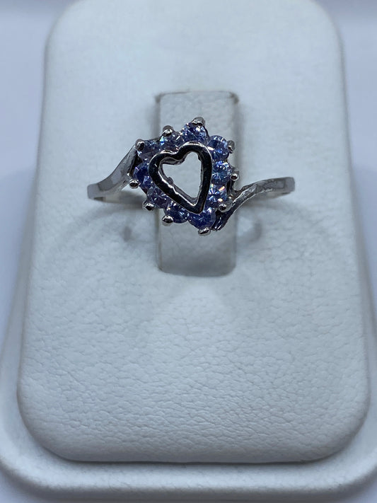 Anillo de plata solitario con circonia morada en halo sobre cojín blanco