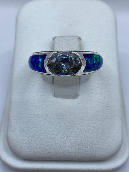 Anillo de plata .950 con circonia multicolor en la mano mostrando fuego azul y verde