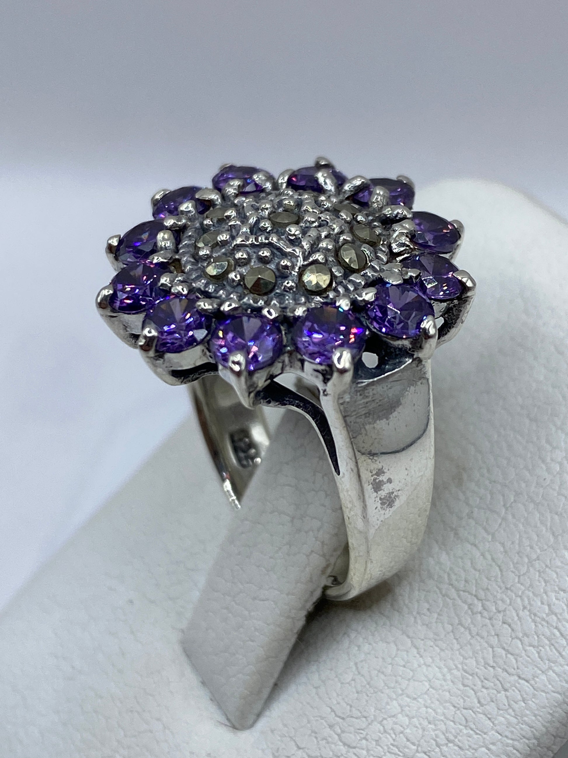 Detalle lateral del anillo coctel morado en plata .925 Taxco sobre fondo blanco