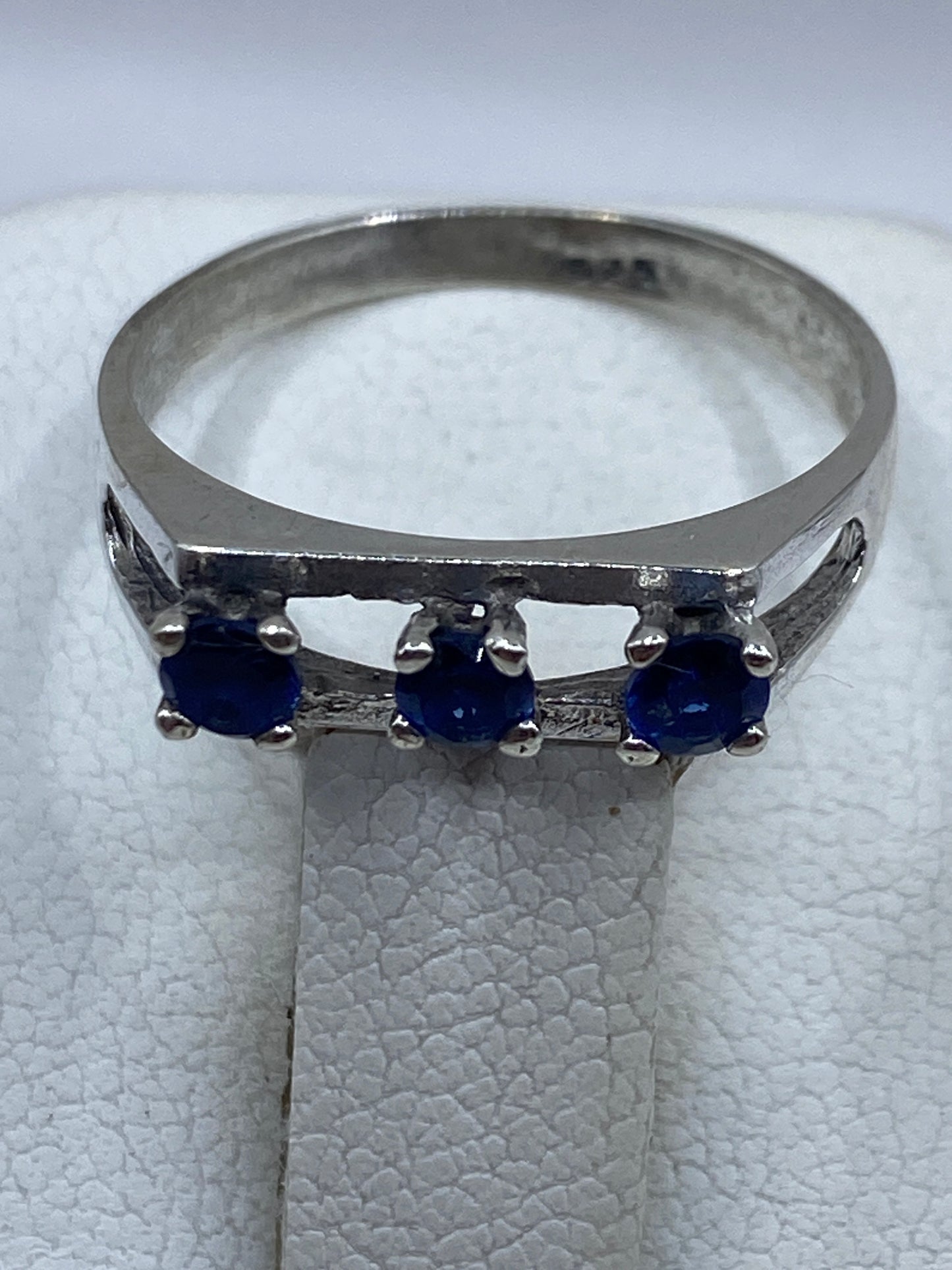 Detalle del engaste de las tres circonias azules en anillo de plata pulida