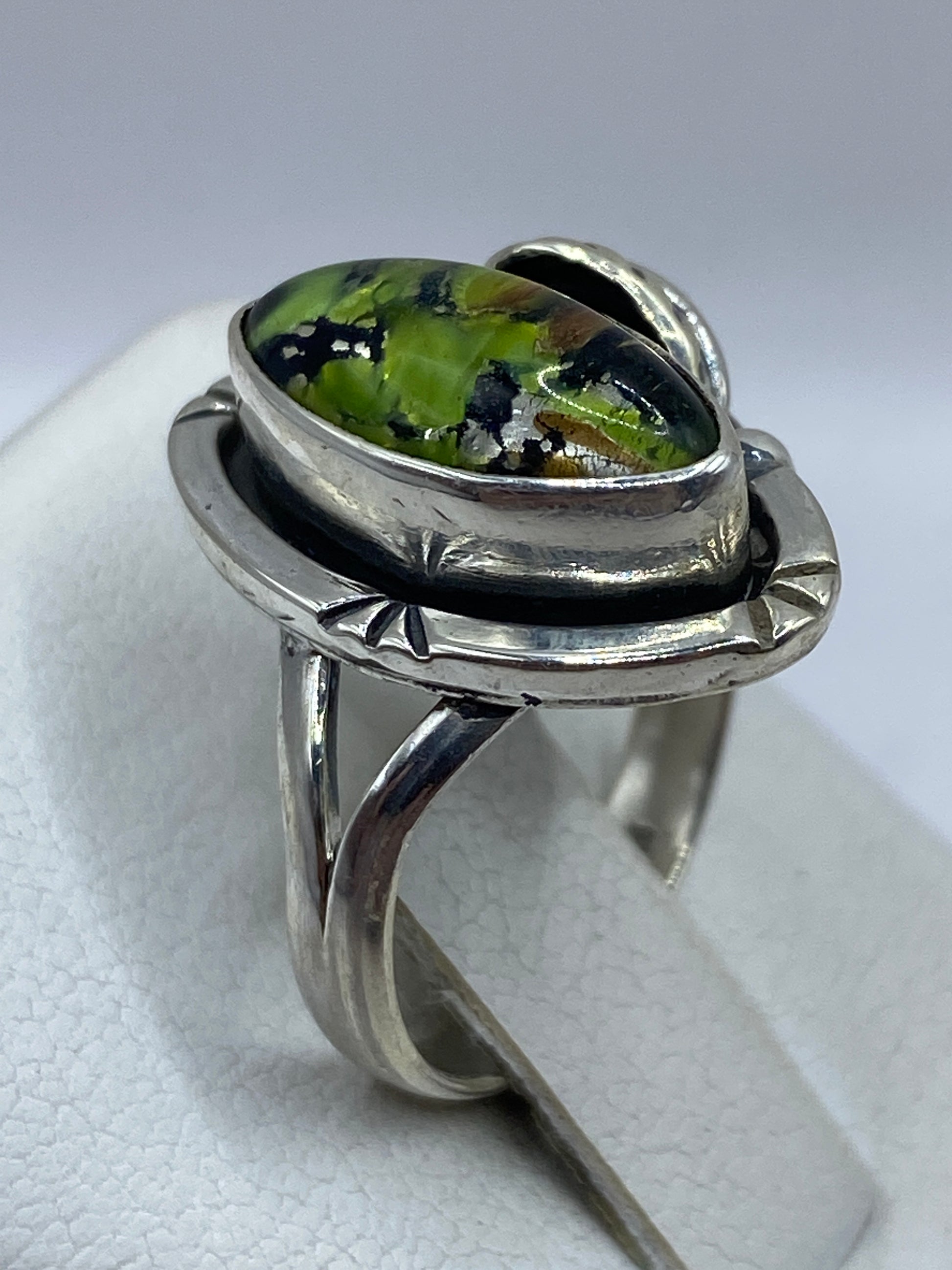 Anillo de opalo fuego en dedo de mujer adulta, brillando con colores naturales