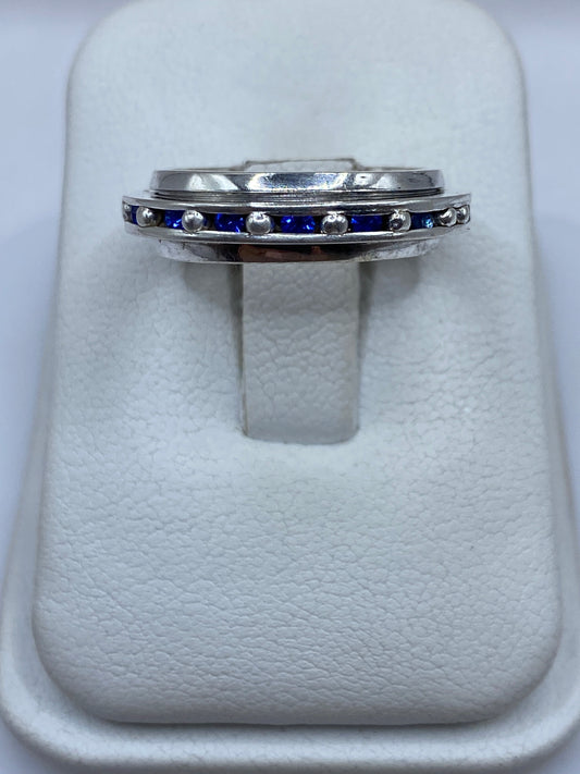 Anillo de plata con circonia azul sobre estuche blanco, vista frontal