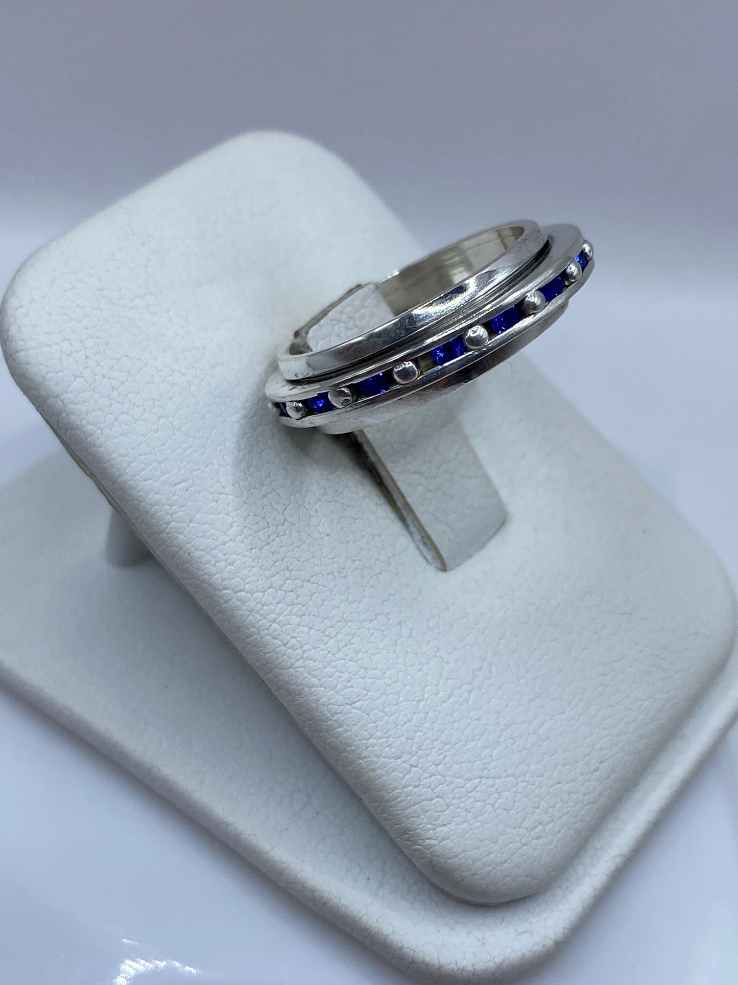 Anillo solitario circonia azul en mano, mostrando el brillo de la piedra