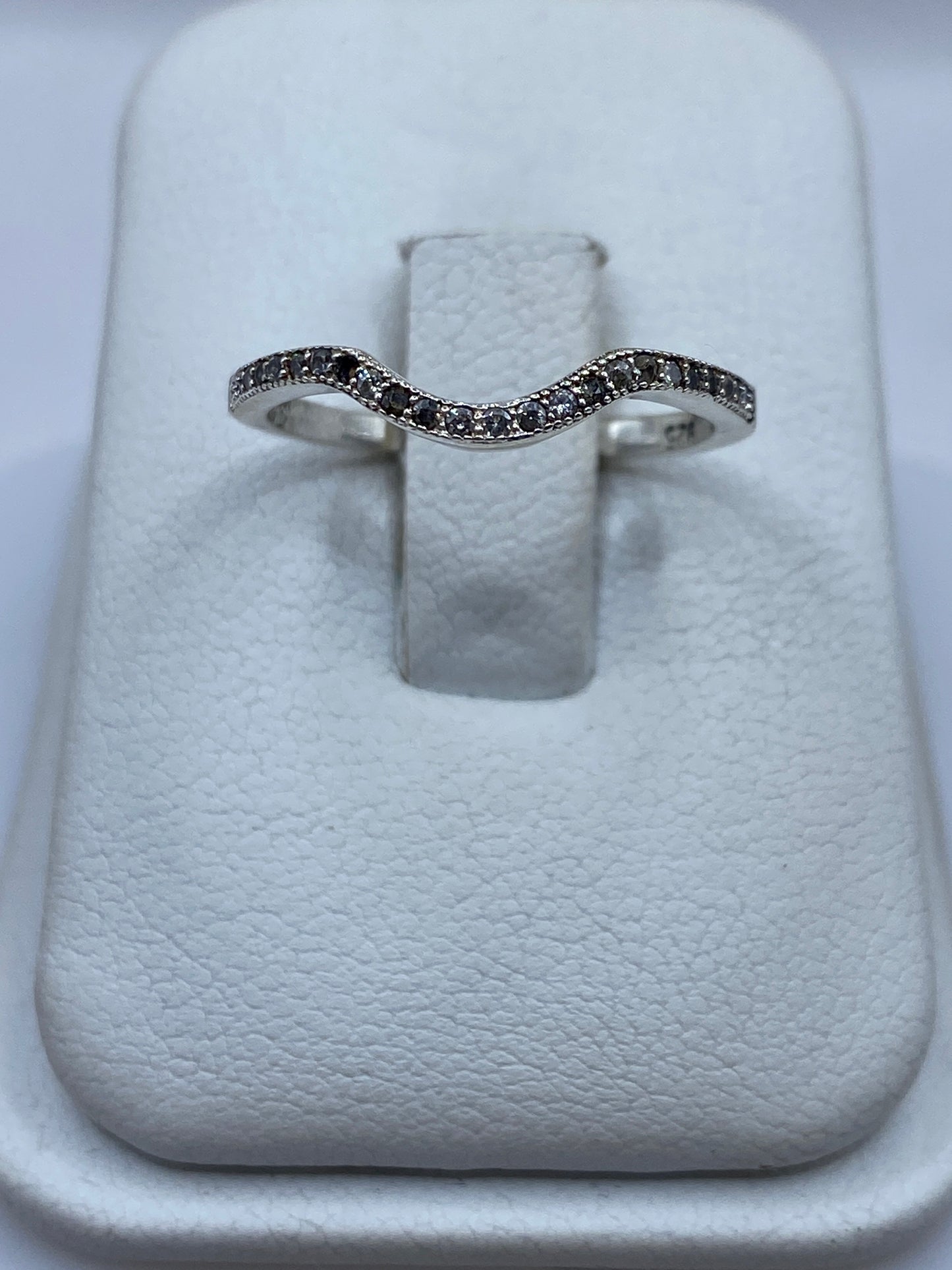 Anillo de plata curva minimalista con circonia blanca en vitrina