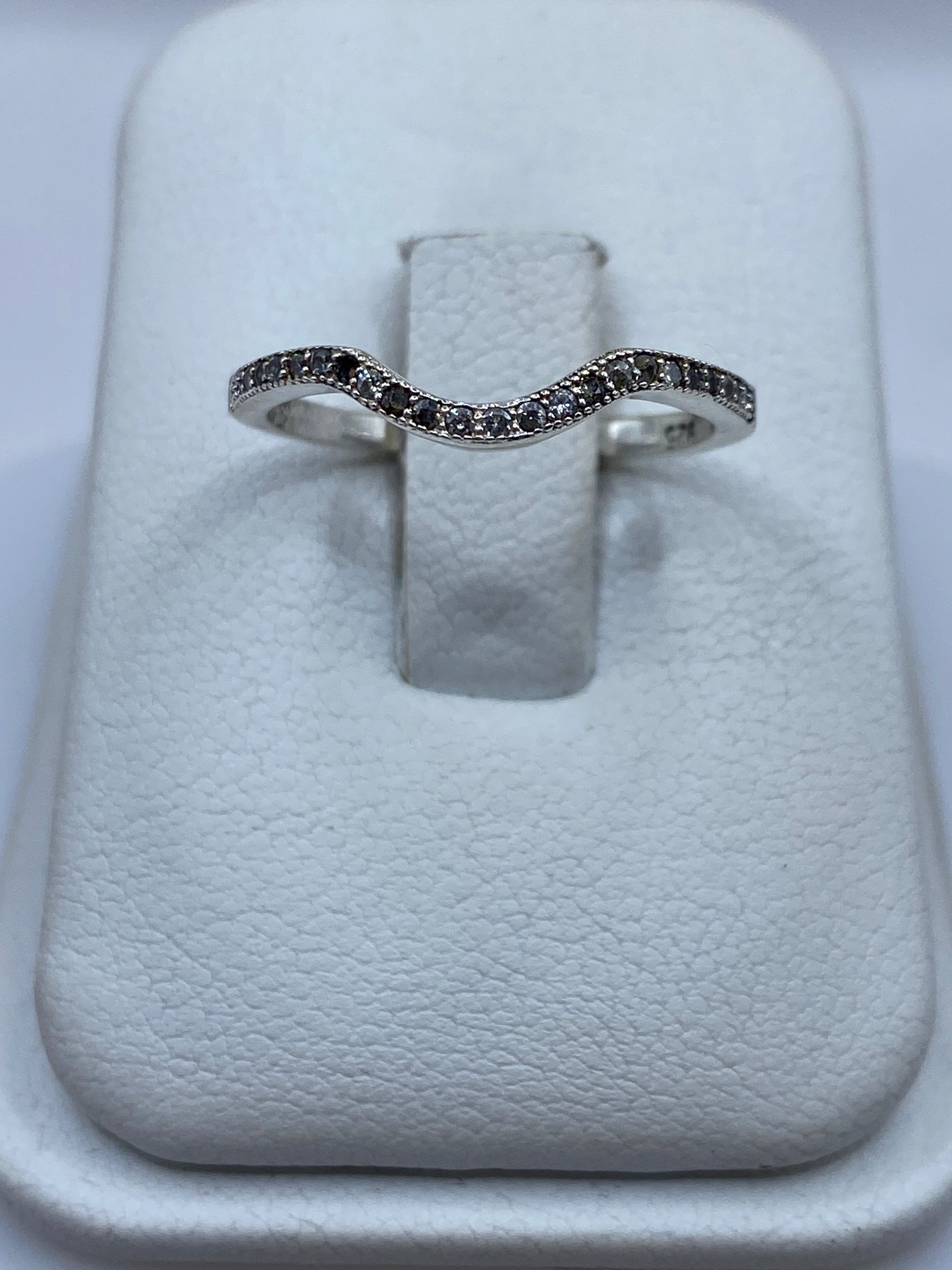 Anillo de plata curva minimalista con circonia blanca en vitrina
