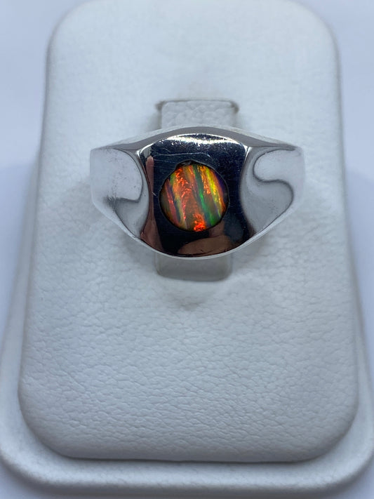 Anillo signet de plata con ópalo de fuego multicolor mostrando juego de colores rojo, naranja y verde