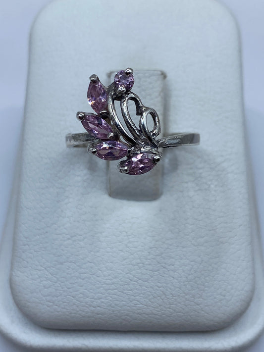 Anillo vintage de plata con circonia rosa en la mano de una mujer, mostrando el brillo de la piedra