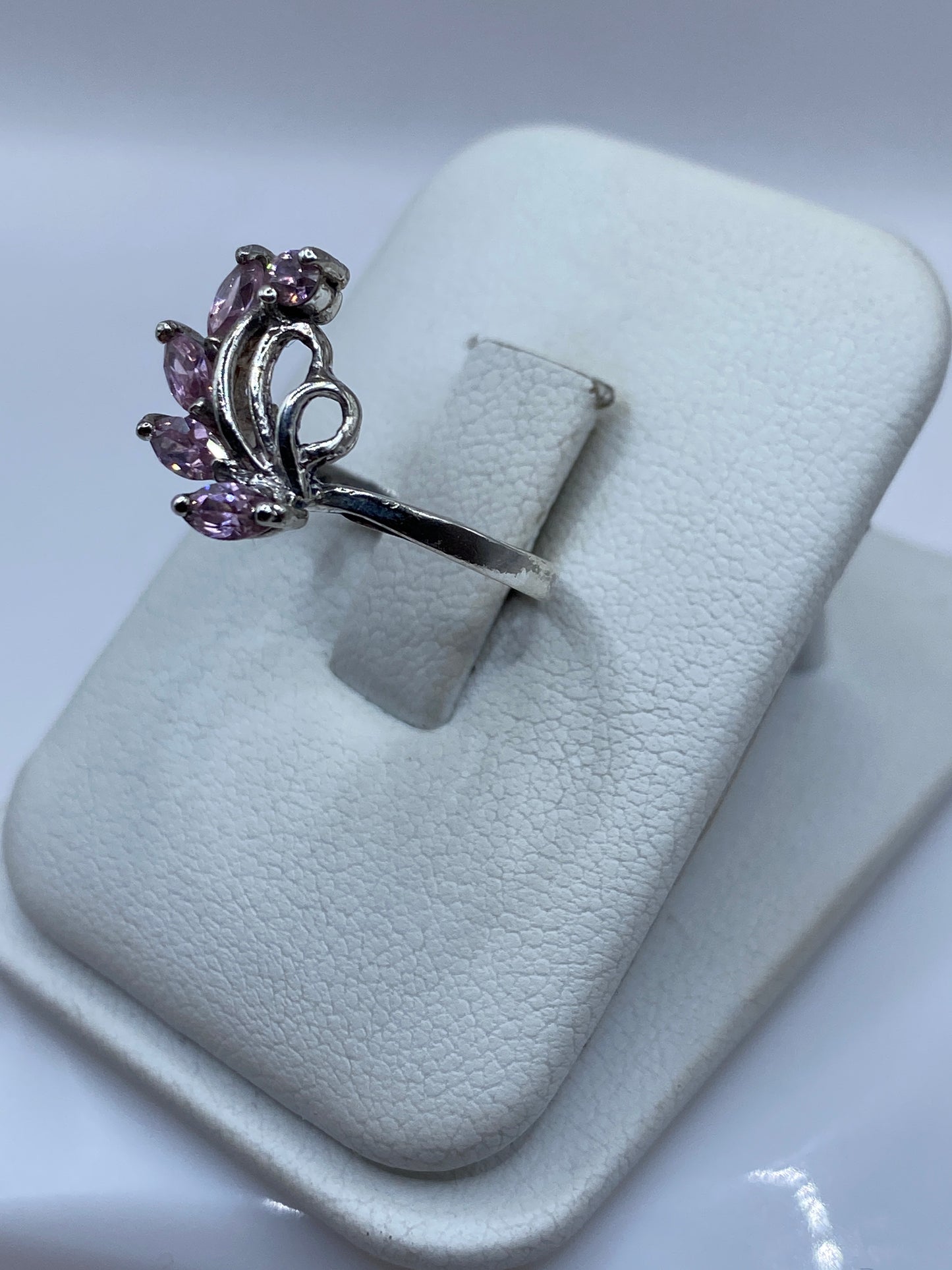 Vista lateral del anillo de circonia rosa en plata .925, detalle del engaste ornamental