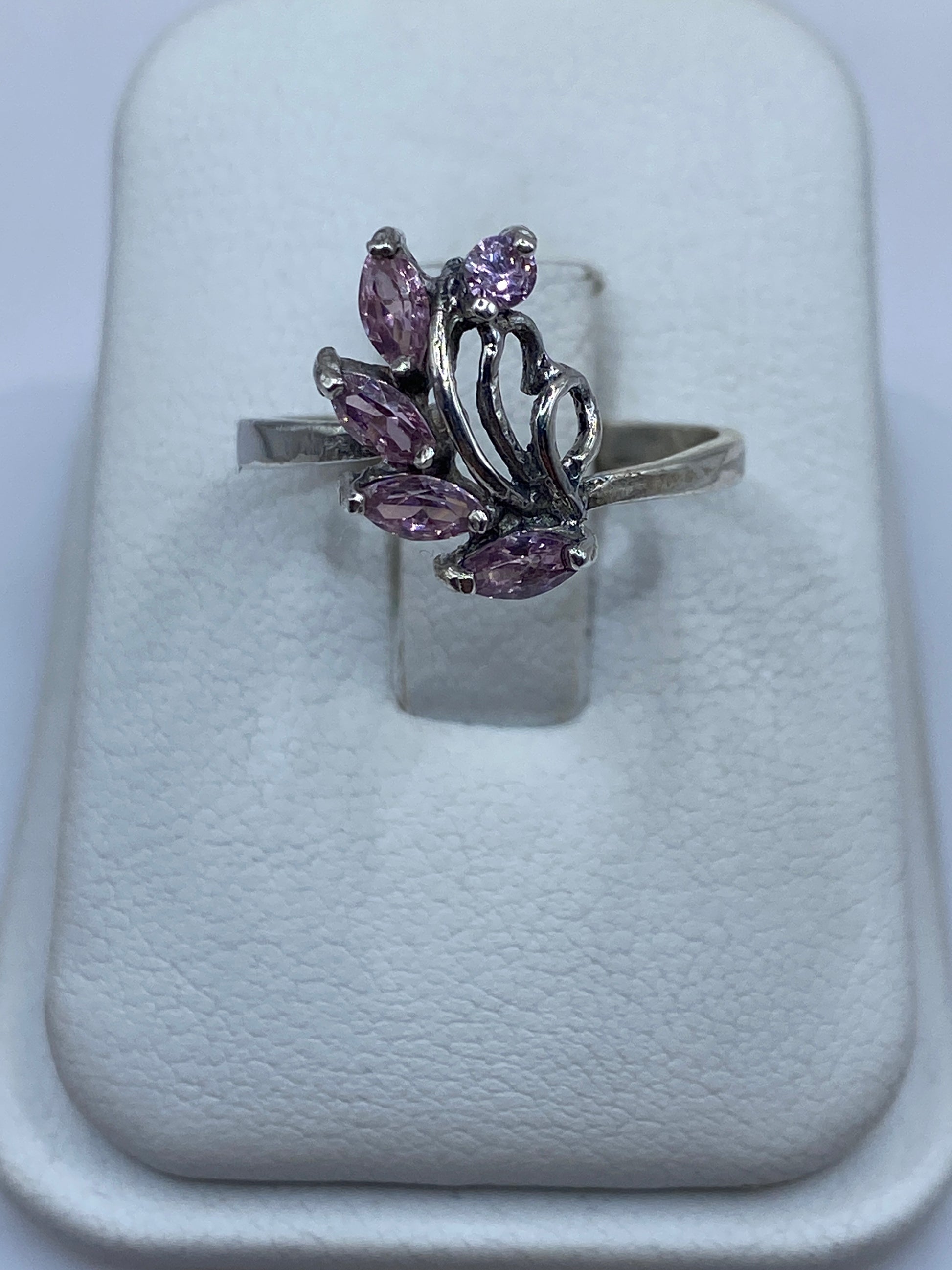 Anillo de plata solitario floral con circonia rosa en mano de mujer