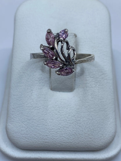 Anillo de plata solitario floral con circonia rosa en mano de mujer