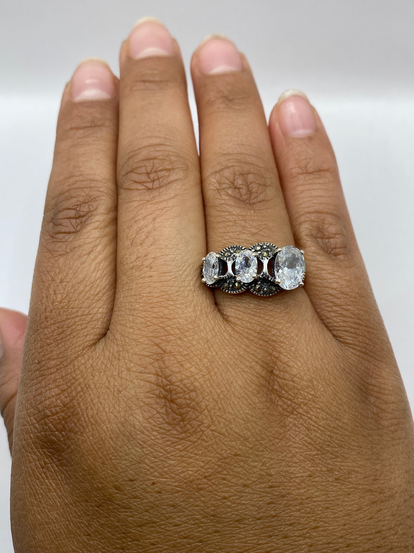 Anillo trinomio en dedo mostrando elegancia geométrica y brillo de circonias blancas