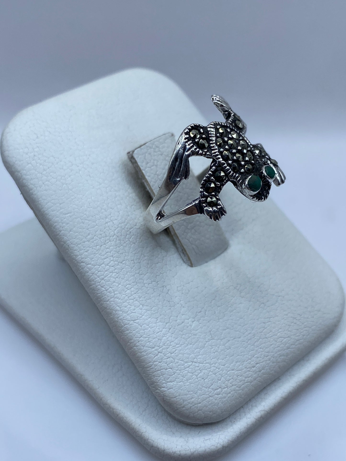 Detalle del engaste de piedra verde en diseño tótem de plata