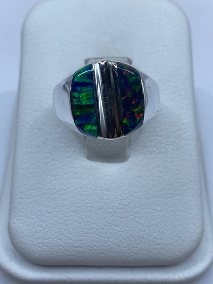 Anillo de plata con ópalo de fuego multicolor mostrando juego de colores azul y verde