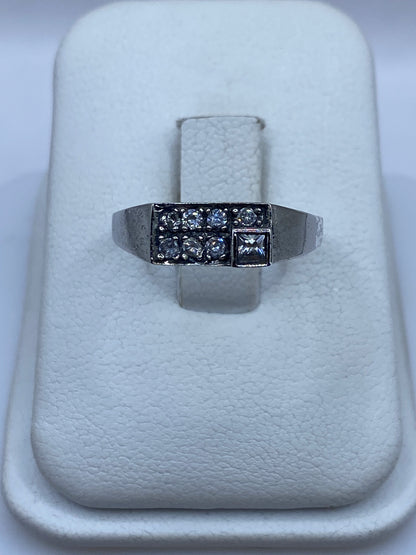 Anillo de plata minimalista con circonia blanca brillante, vista frontal en bandeja blanca