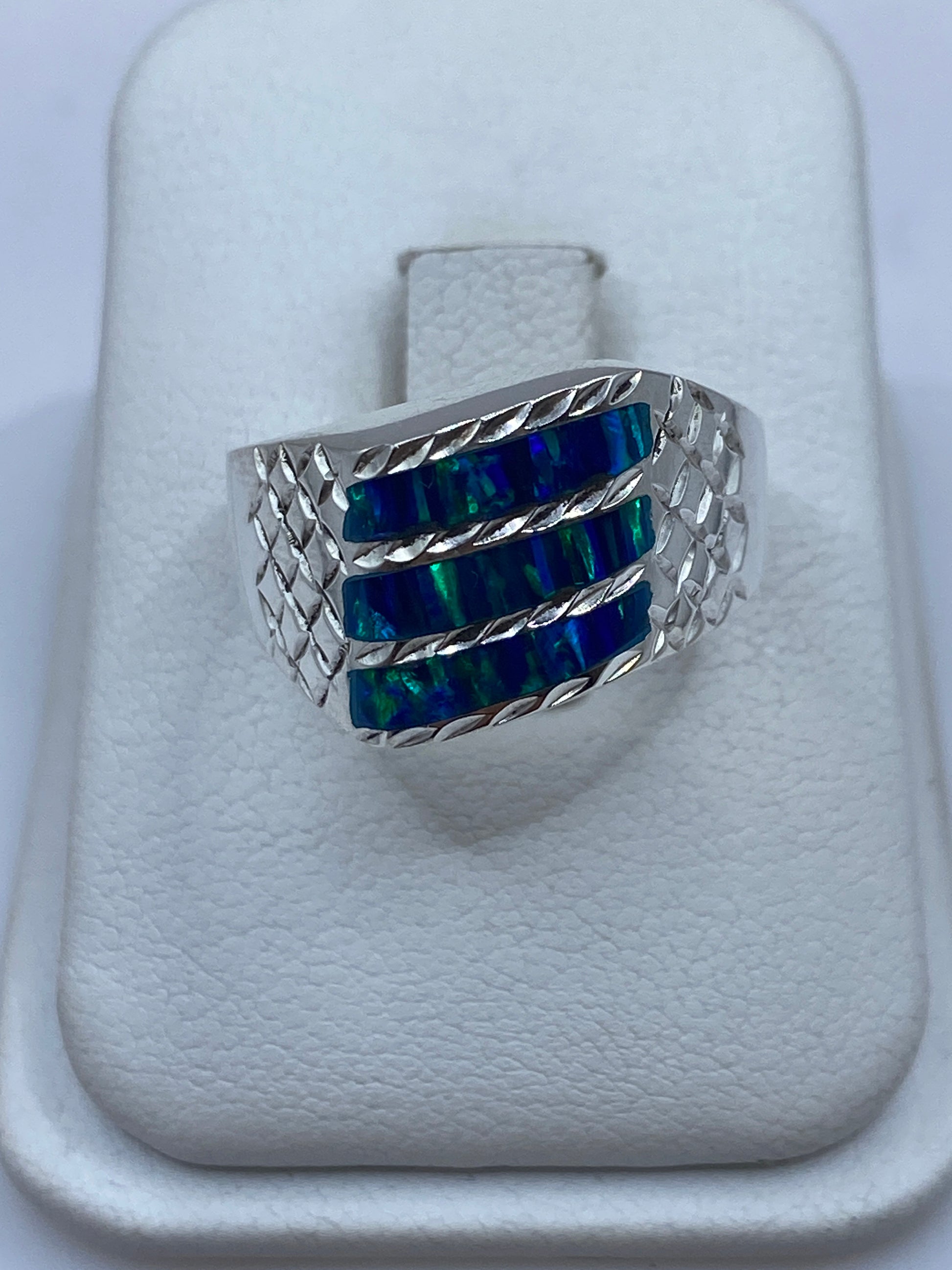 Anillo de plata .950 con ópalo de fuego azul y banda texturizada en estuche blanco
