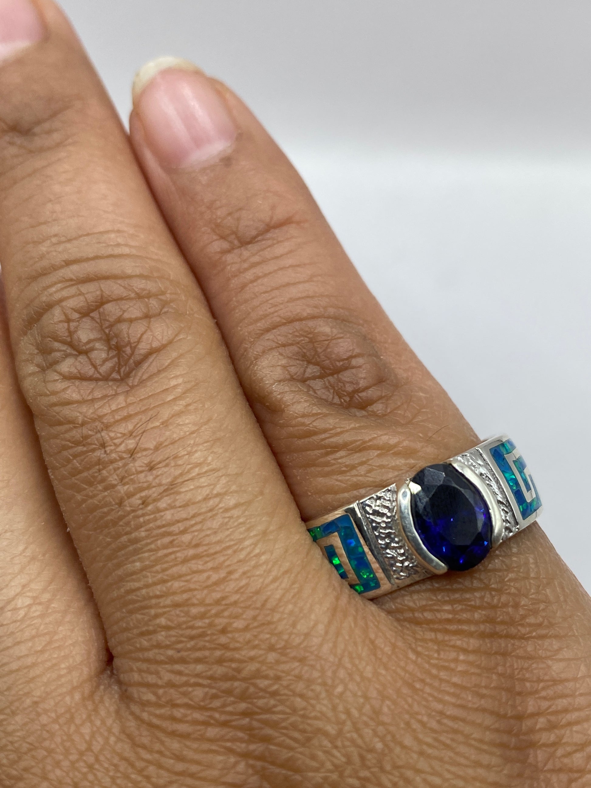Anillo solitario con ópalo de fuego sobre fondo neutro mostrando sello 950
