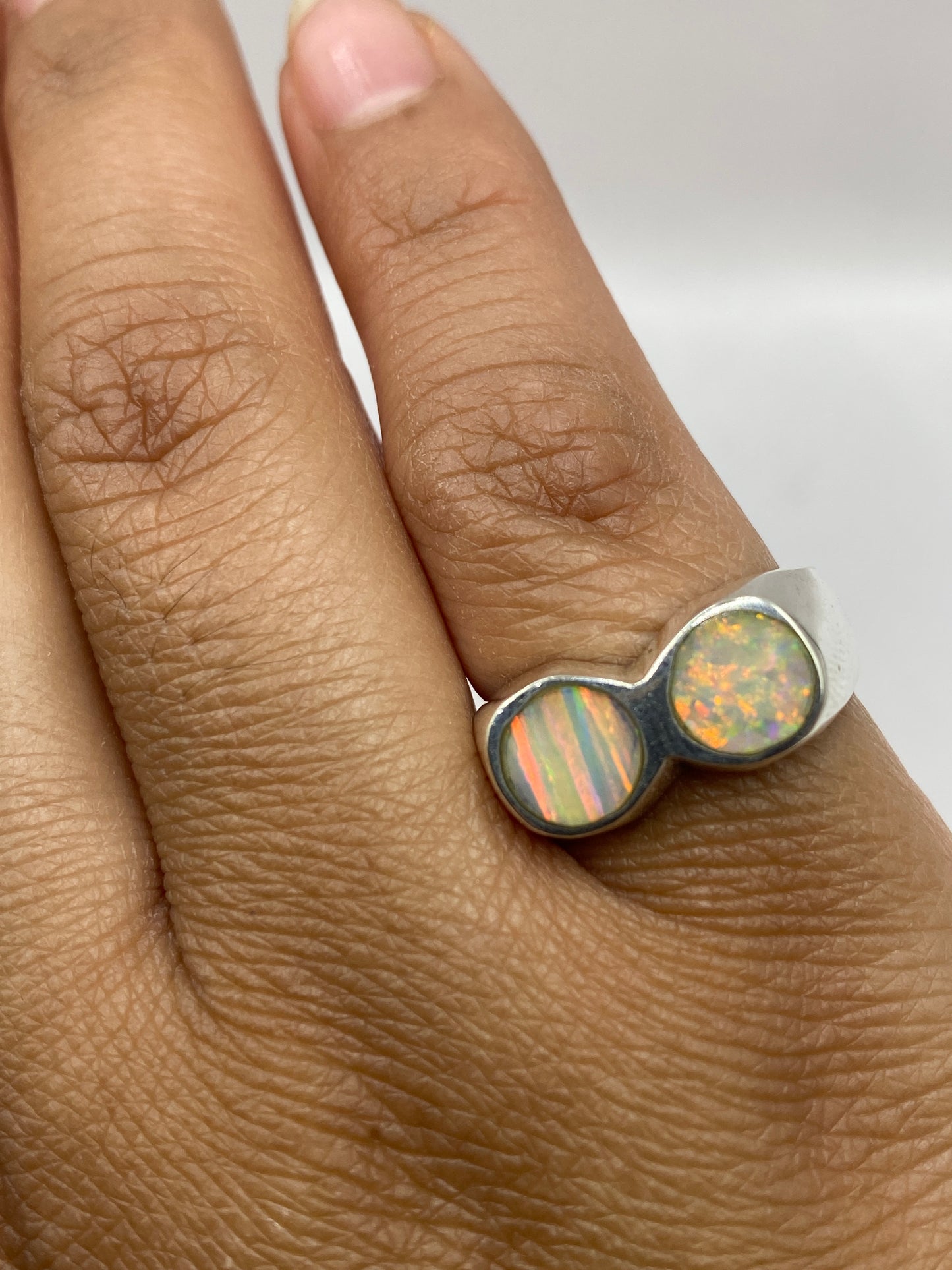 Anillo en la mano mostrando el peso sustancial y el brillo del ópalo bajo luz natural