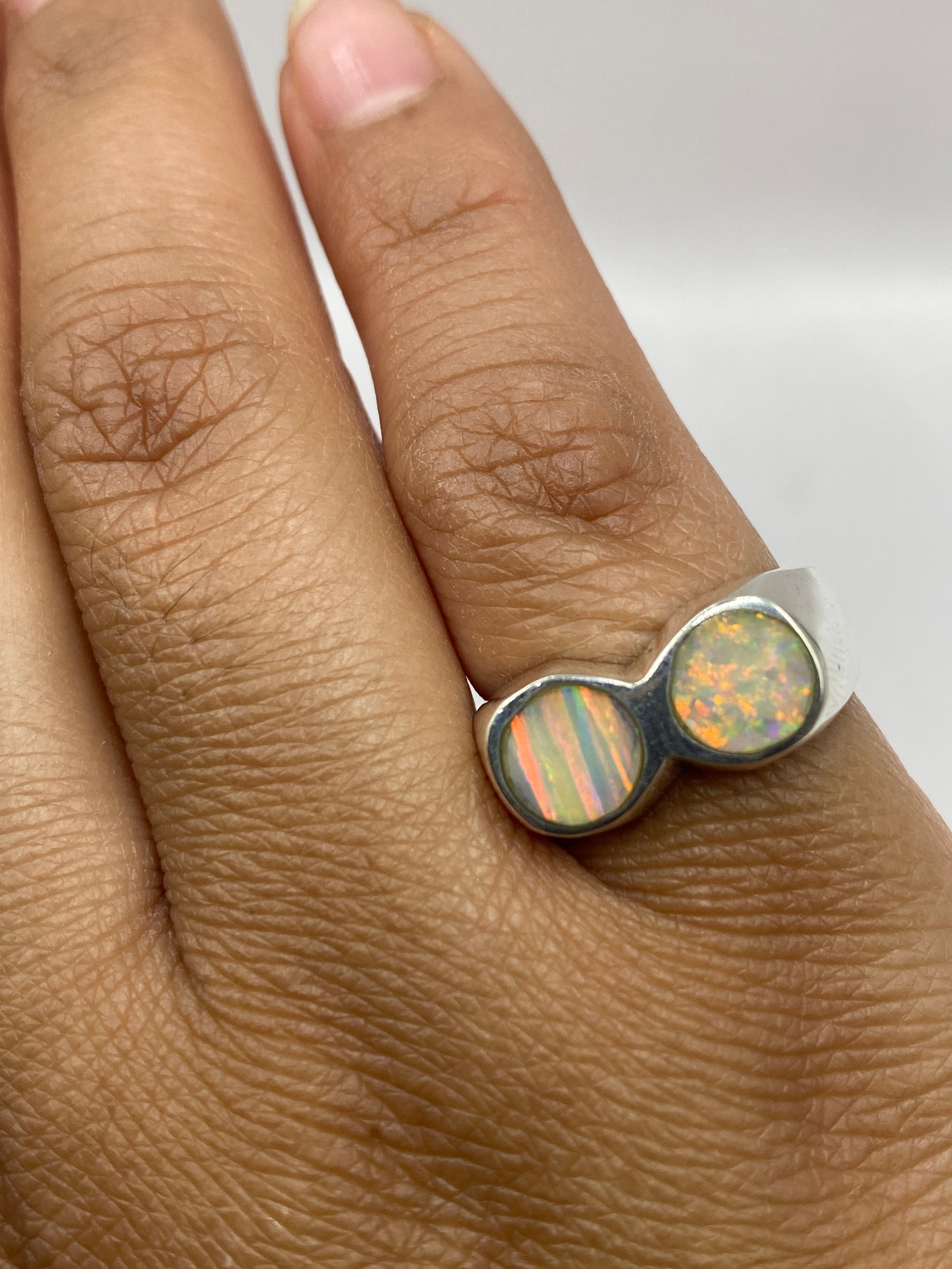 Anillo en la mano mostrando el peso sustancial y el brillo del ópalo bajo luz natural