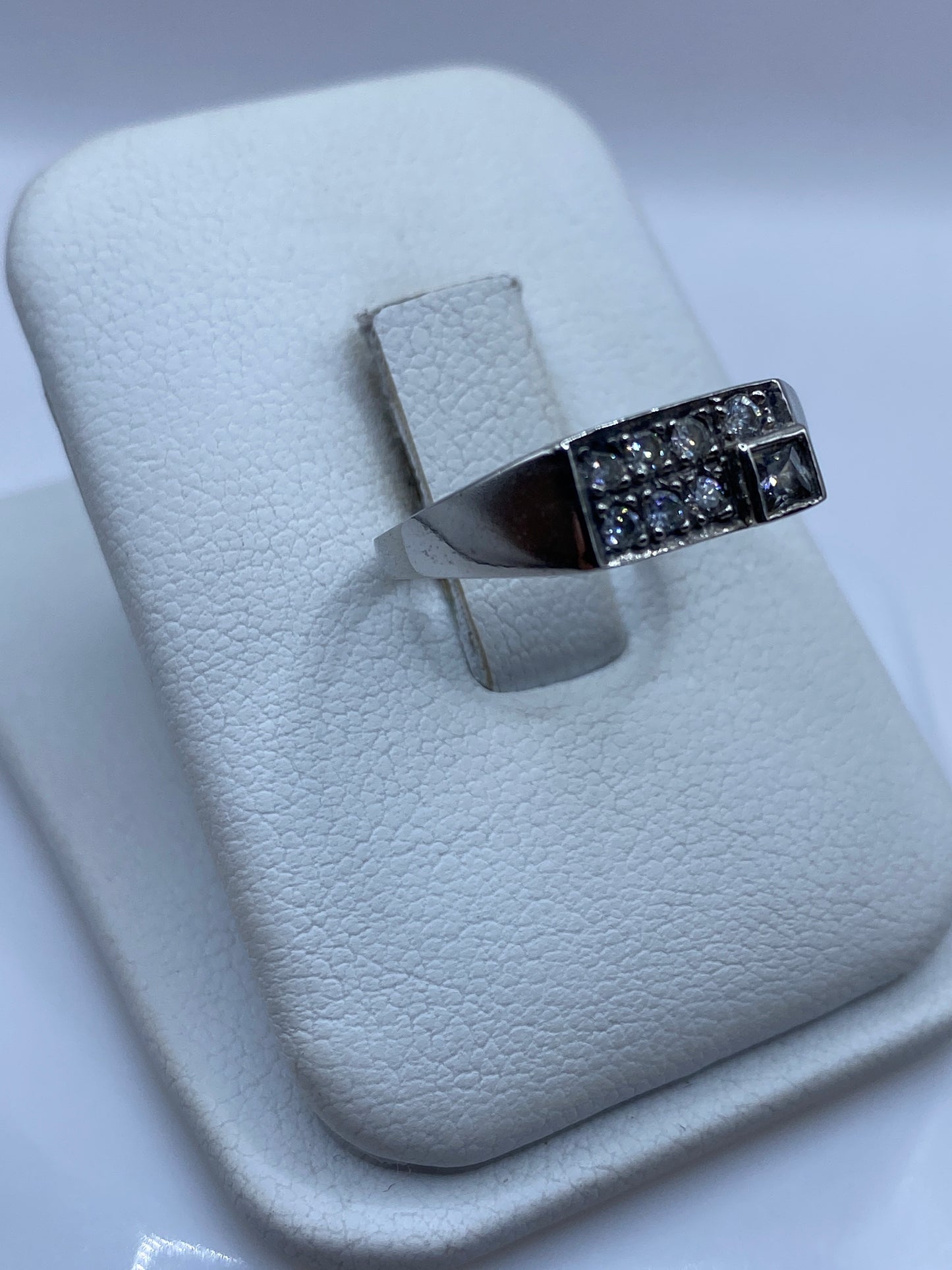 Vista frontal del anillo de plata .925 con piedra blanca en mano de mujer