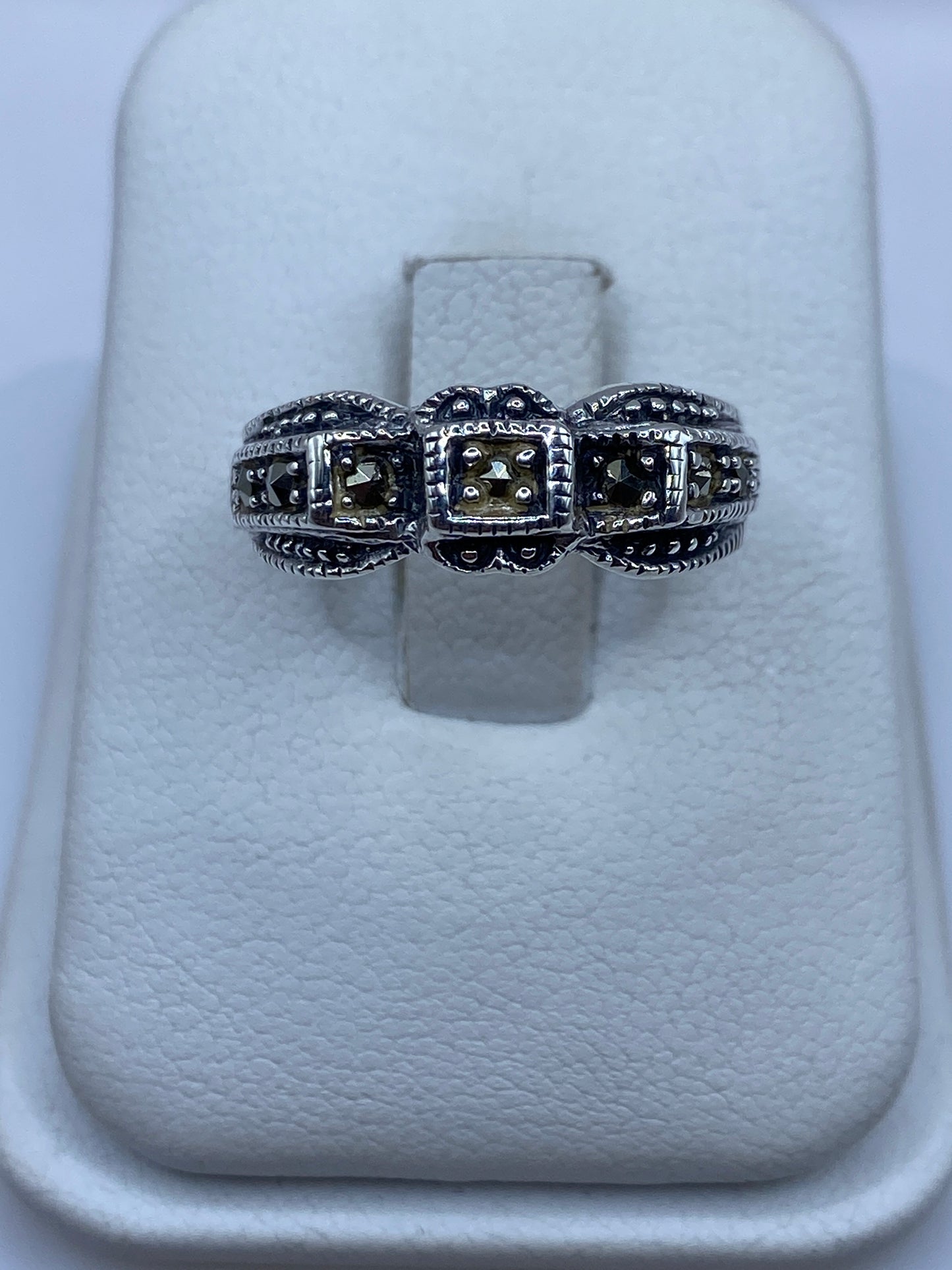 Anillo de plata .925 con tres compartimentos texturizados en la mano de una mujer