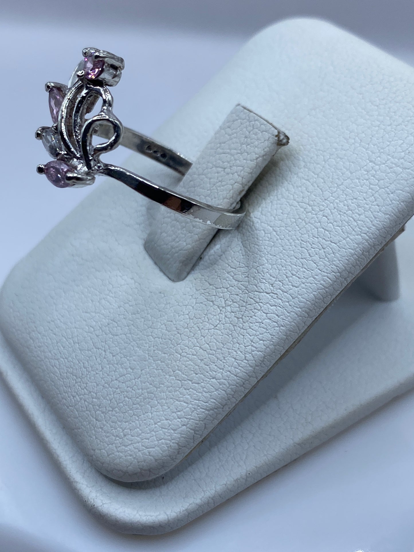 Detalle lateral del anillo delicado con circonia rosa brillante