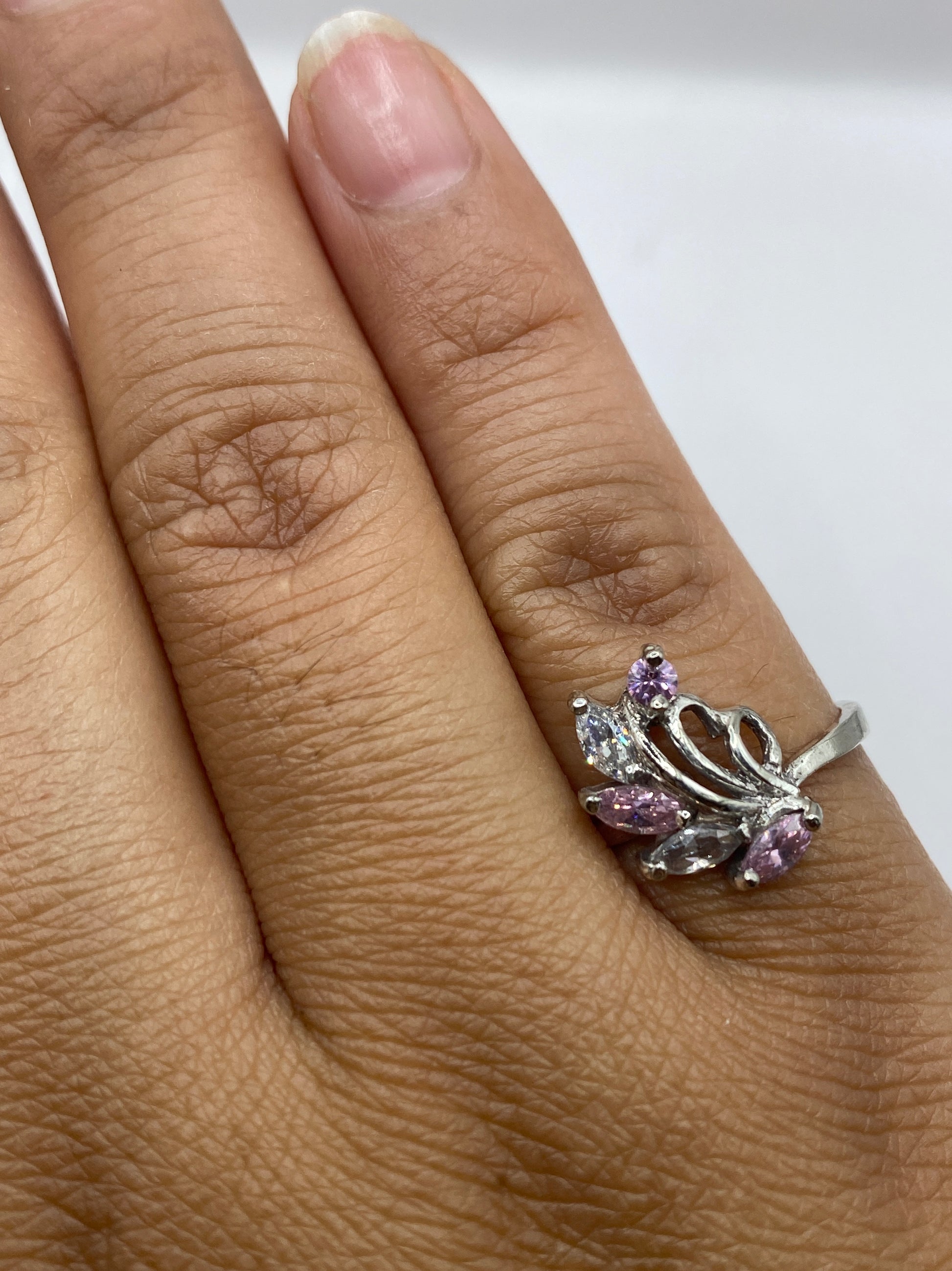 Anillo de plata con piedra rosa sobre fondo gris, vista completa
