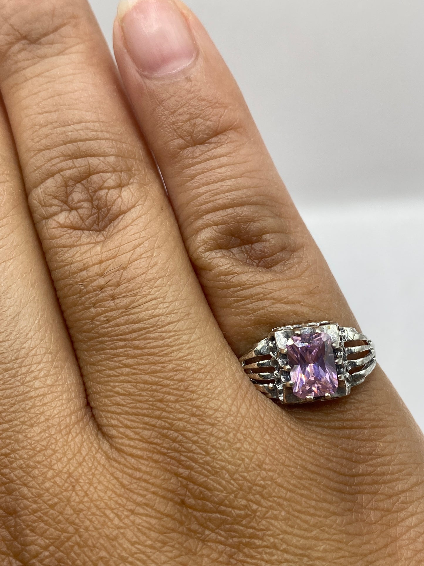 Anillo solitario puesto en mano mostrando el color rosa cálido de la circonia
