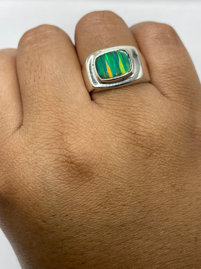 Anillo de plata con opalo de fuego sobre fondo blanco, mostrando el sello .950 MEXICO