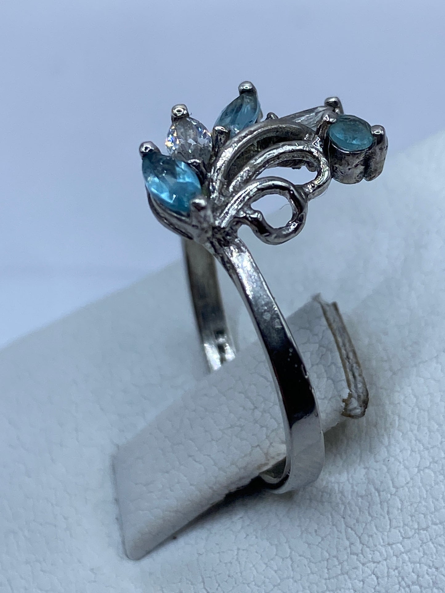 Anillo delicado de plata en la mano de mujer, mostrando el brillo de la piedra