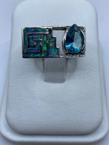 Anillo de plata .950 con ópalo de fuego azul cielo, diseño geométrico étnico sobre fondo blanco