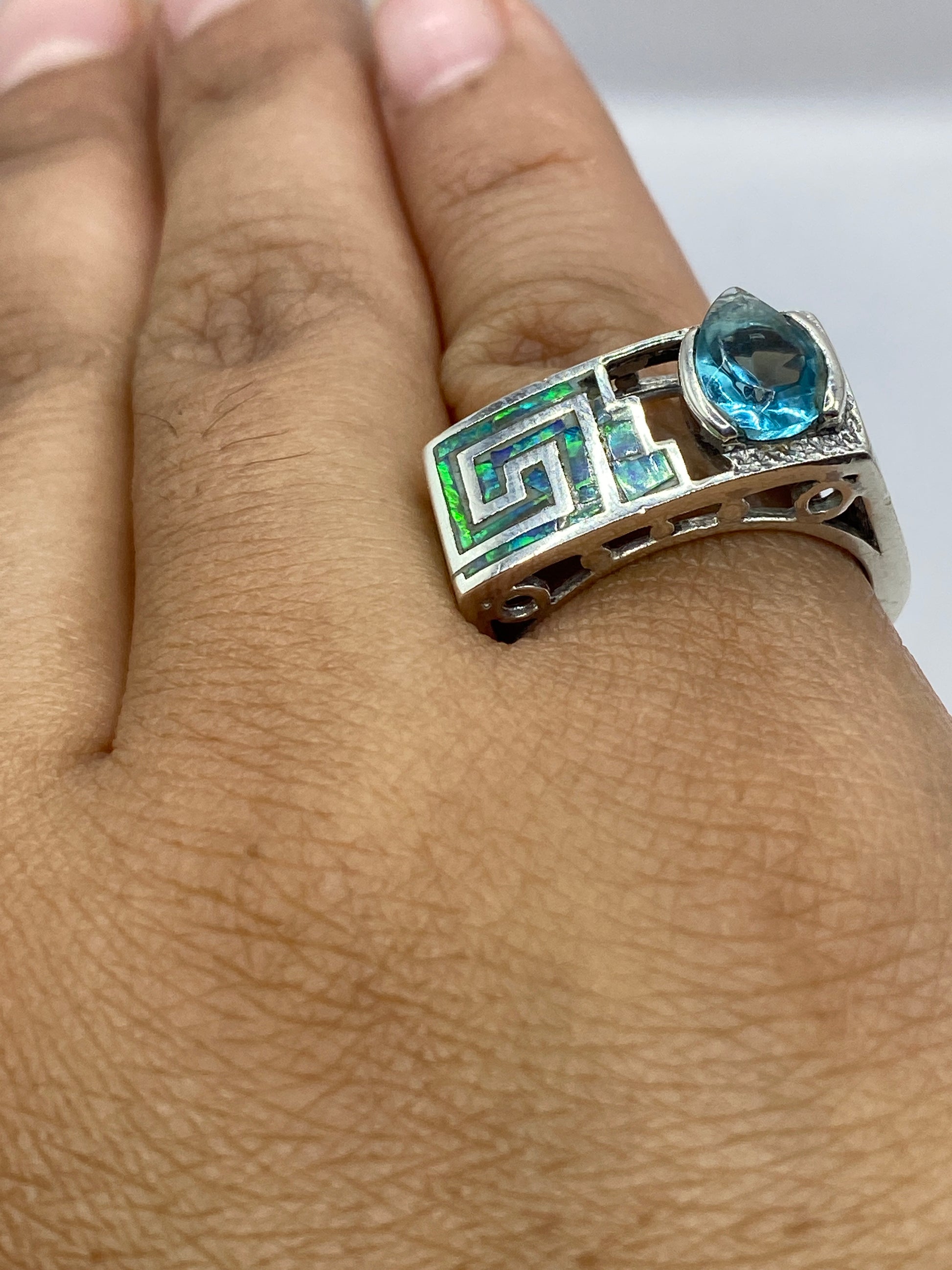 Anillo colocado en dedo mostrando el ópalo de fuego con luz natural
