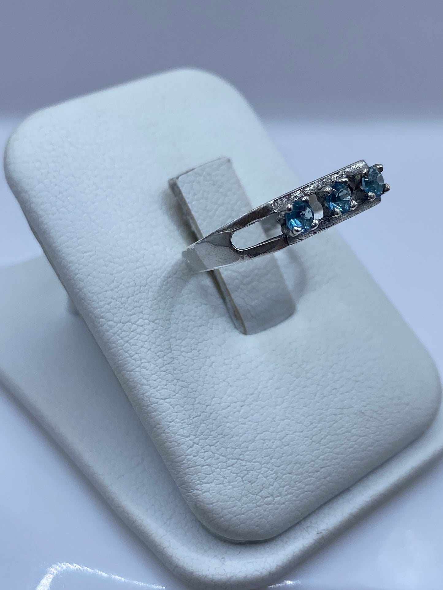 Detalle del anillo minimalista de plata con piedra azul en prongs