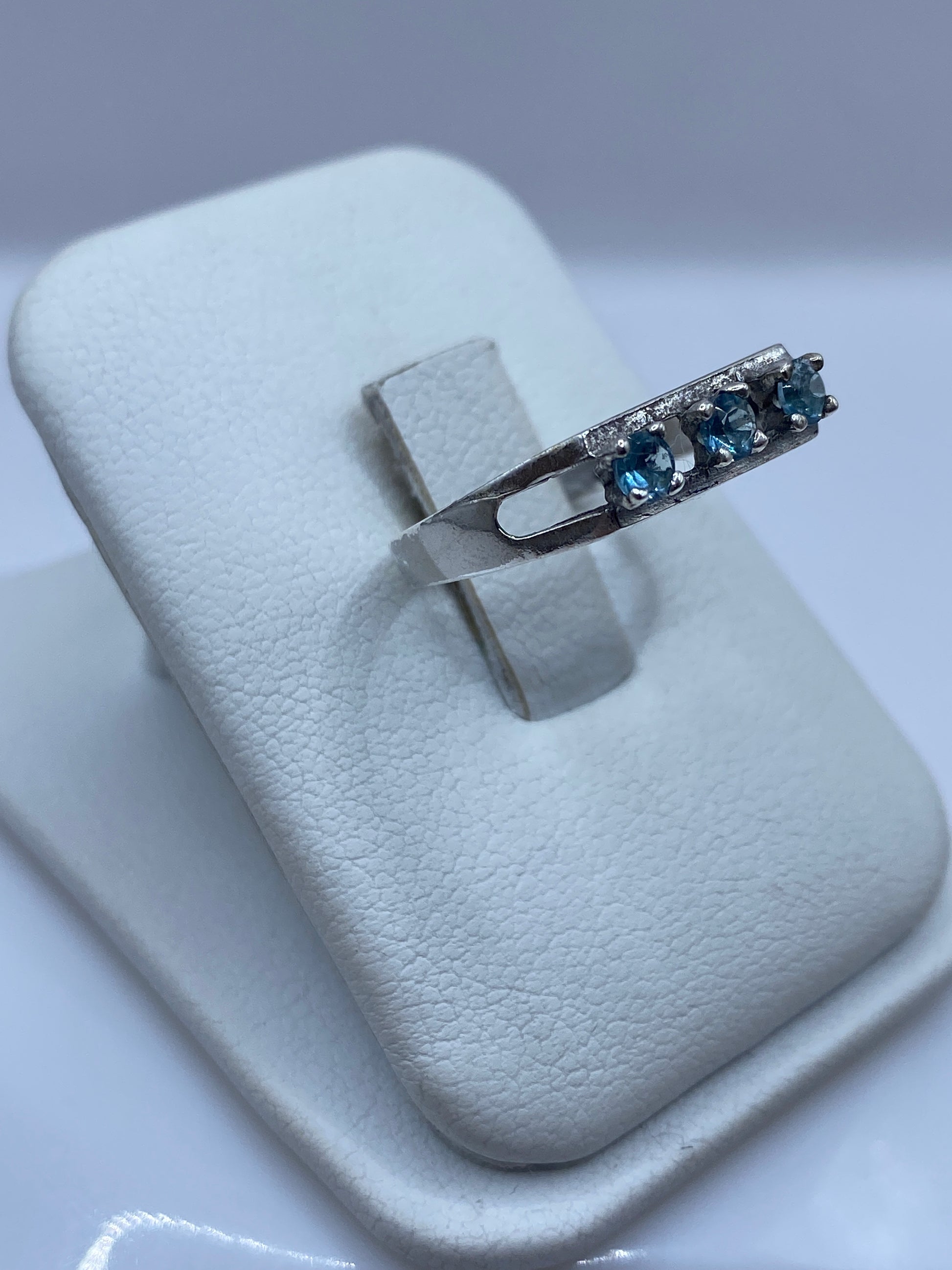 Detalle del anillo minimalista de plata con piedra azul en prongs