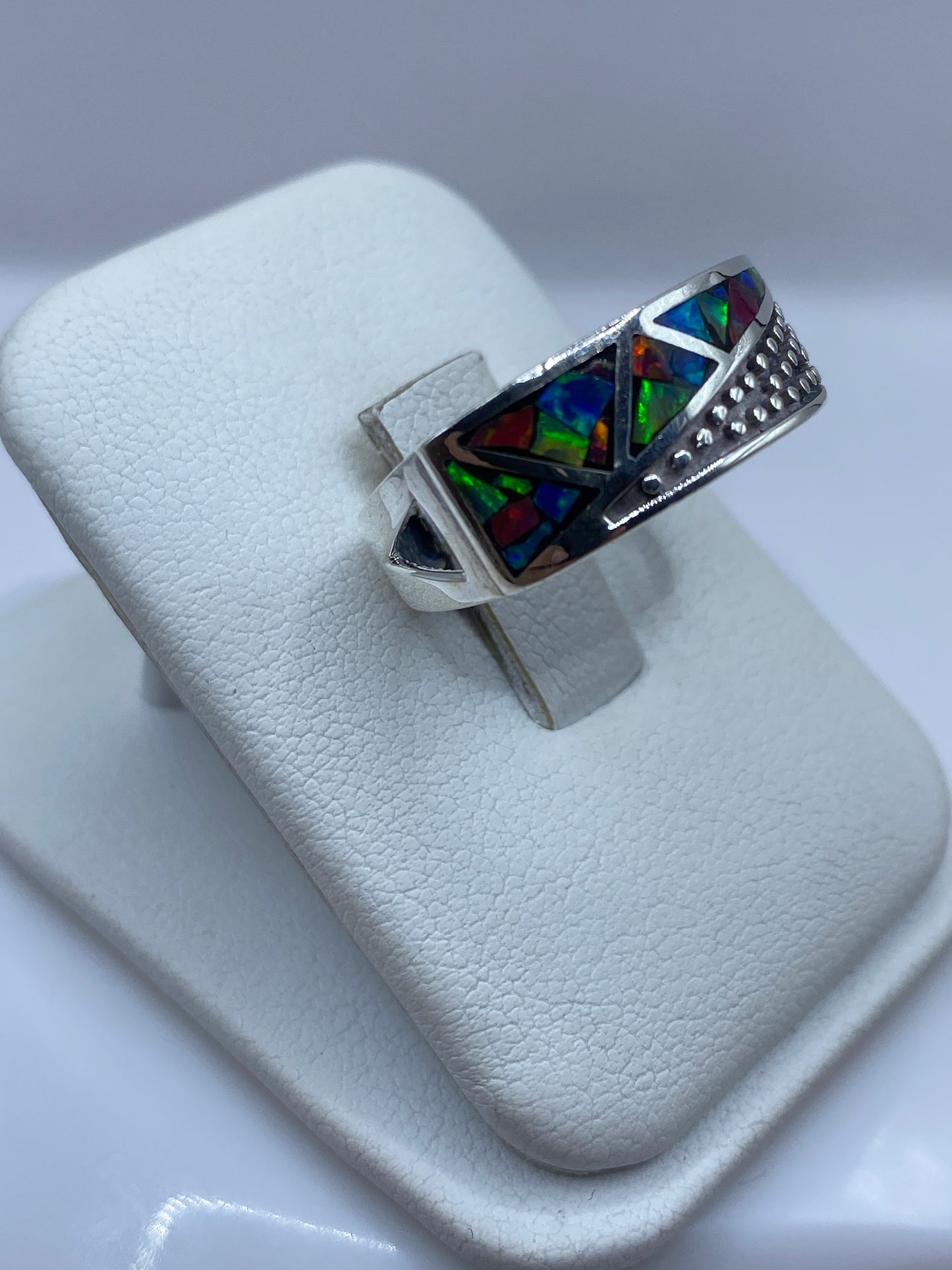 Vista lateral del anillo mostrando bandas triangulares en plata pura y textura puntillada