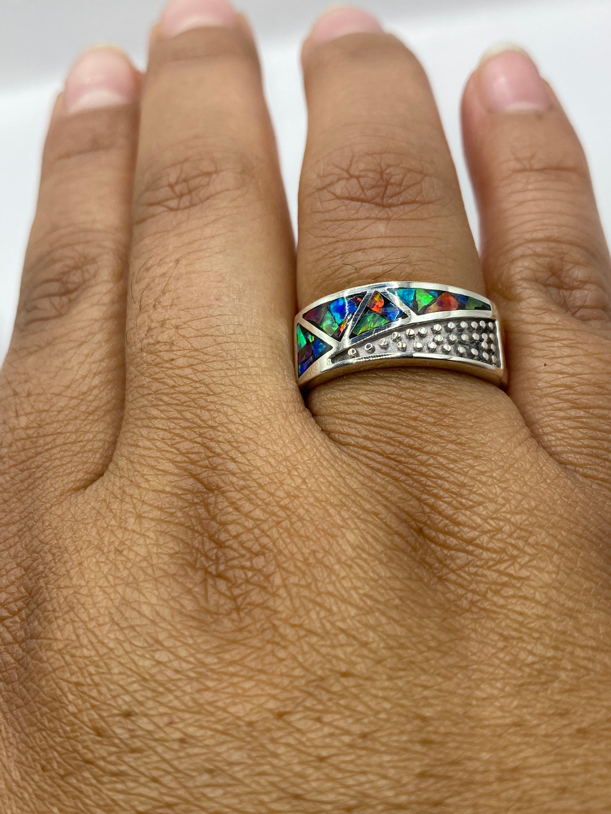 Anillo en dedo de hombre mostrando presencia y brillo del ópalo multicolor