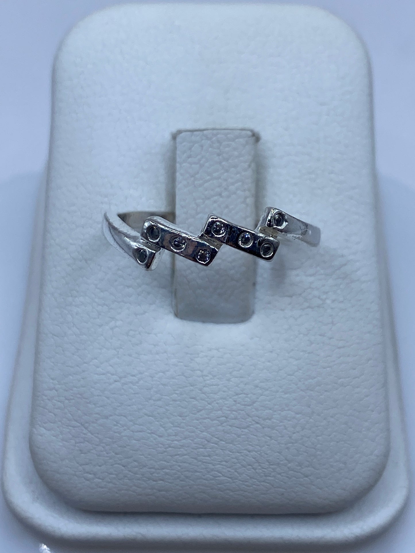 Anillo solitario de plata con circonia cristalina facetada en la mano de una mujer