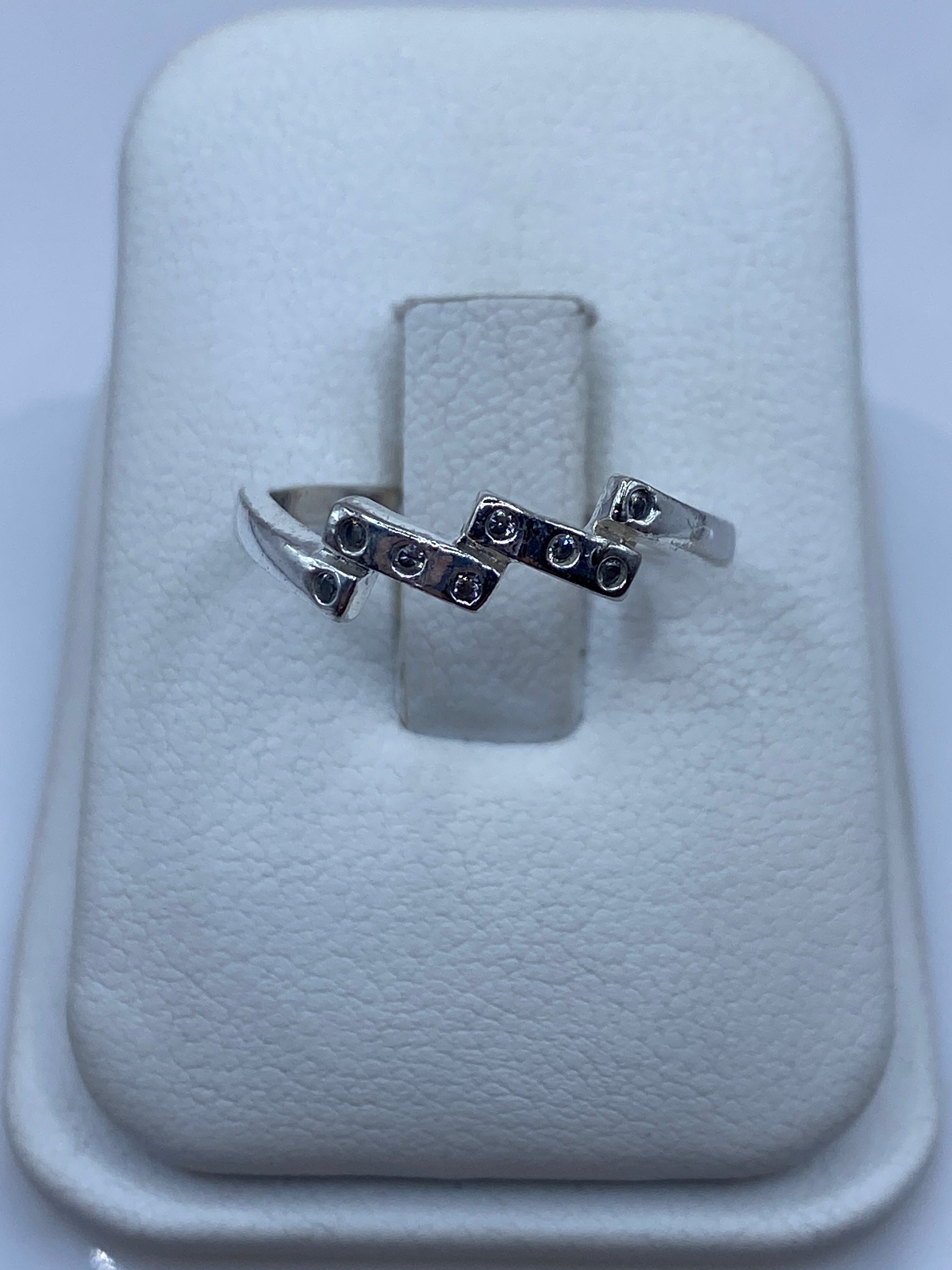 Anillo solitario de plata con circonia cristalina facetada en la mano de una mujer