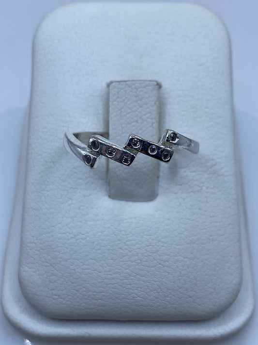 Anillo solitario de plata con circonia cristalina facetada en la mano de una mujer