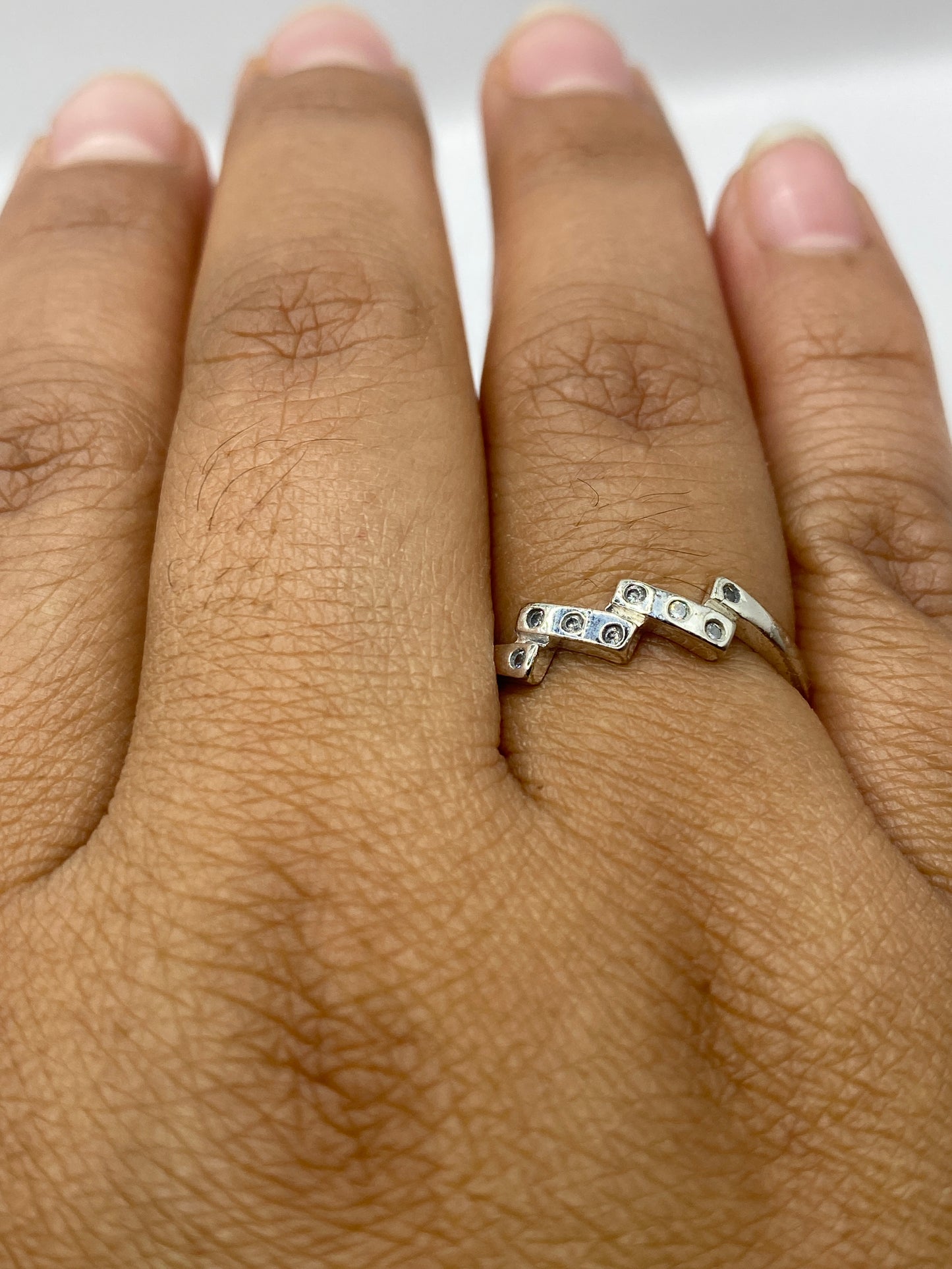 Anillo solitario sobre fondo blanco mostrando la luz refractada de la circonia