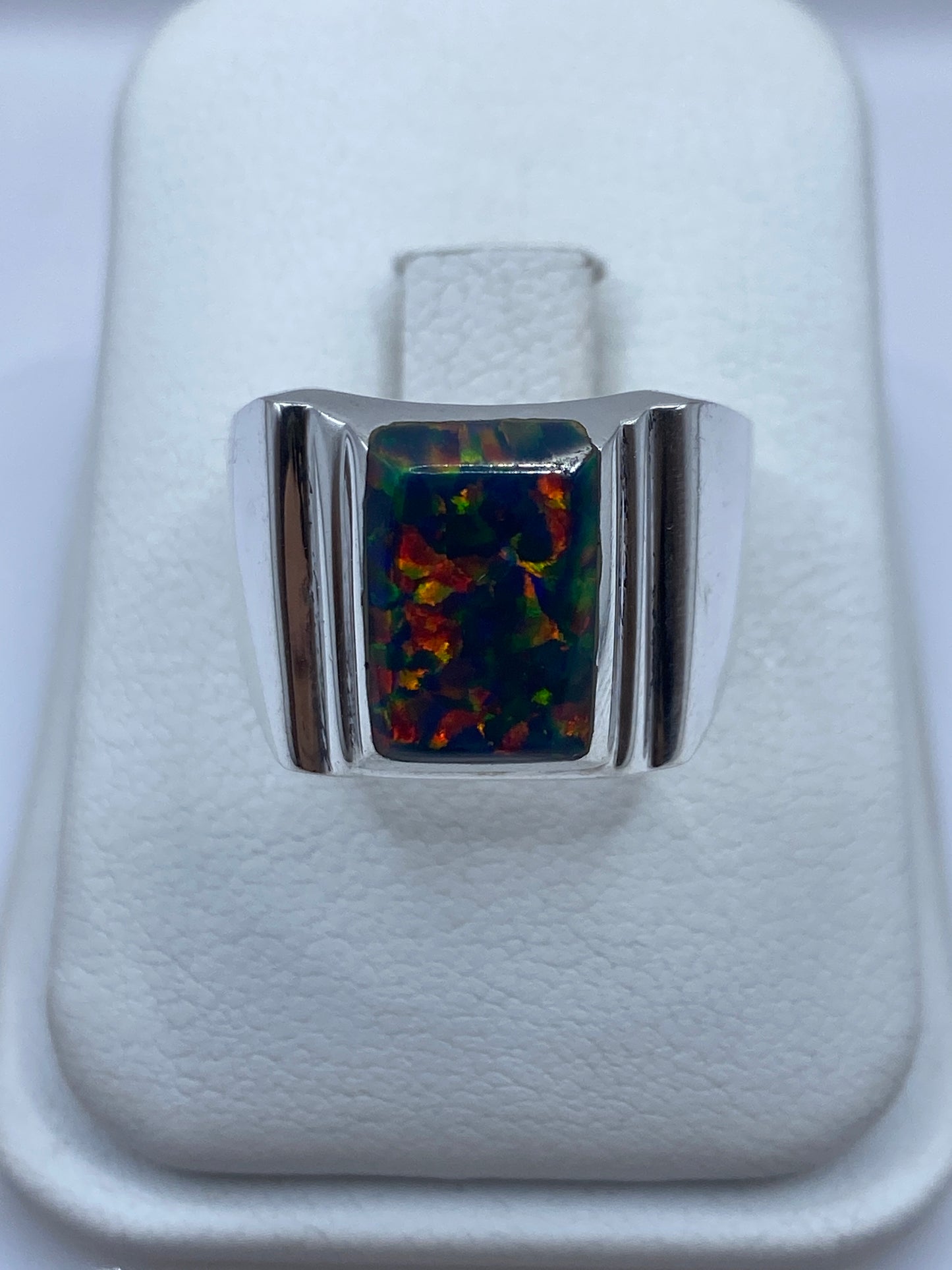 Anillo masivo de plata con ópalo de fuego multicolor mostrando destellos rojo, verde y amarillo