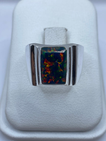 Anillo masivo de plata con ópalo de fuego multicolor mostrando destellos rojo, verde y amarillo