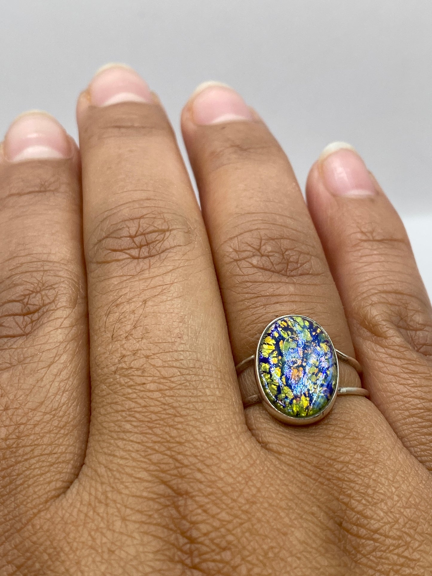 Anillo en dedo mostrando el brillo natural de la piedra multicolor