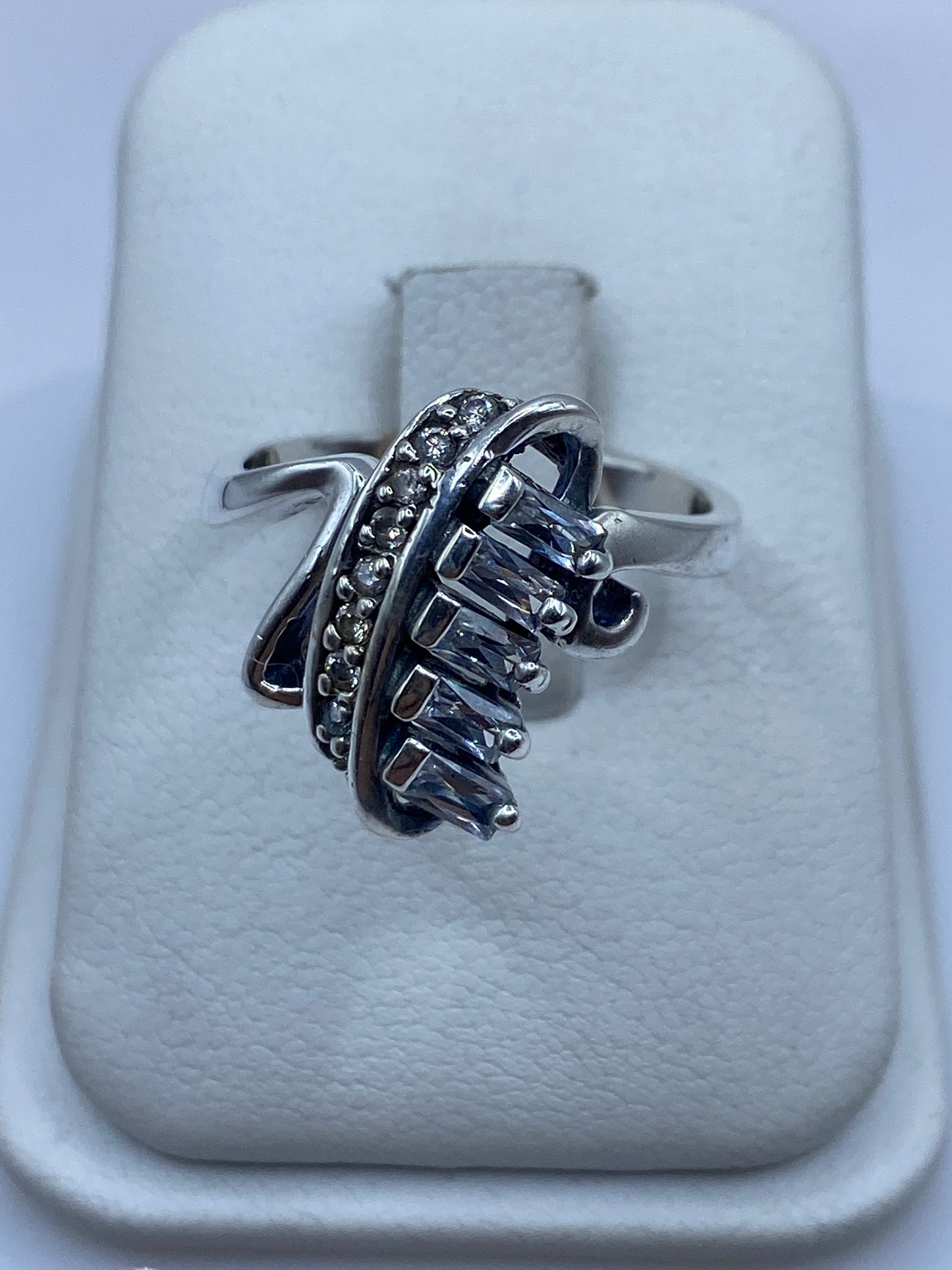 Anillo de plata con circonia blanca brillante en la mano de una mujer, mostrando el fuego de la piedra