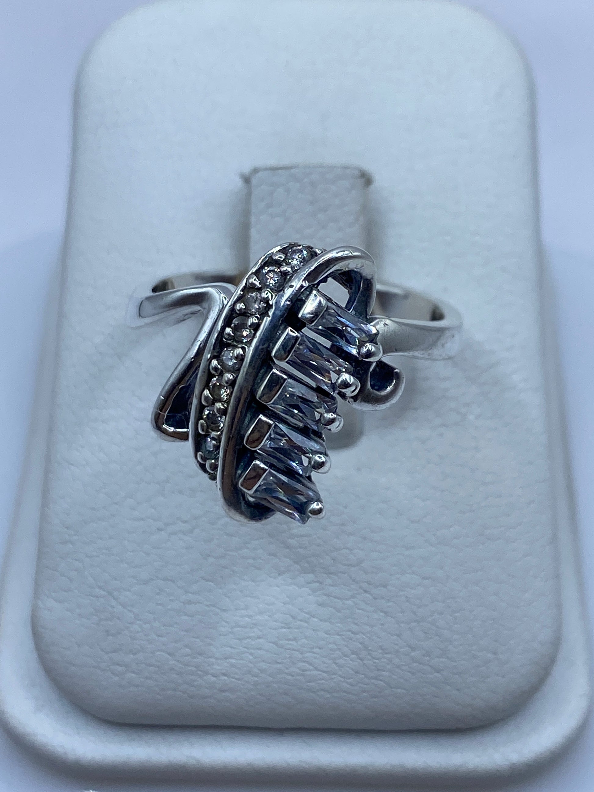 Anillo de plata con circonia blanca brillante en la mano de una mujer, mostrando el fuego de la piedra