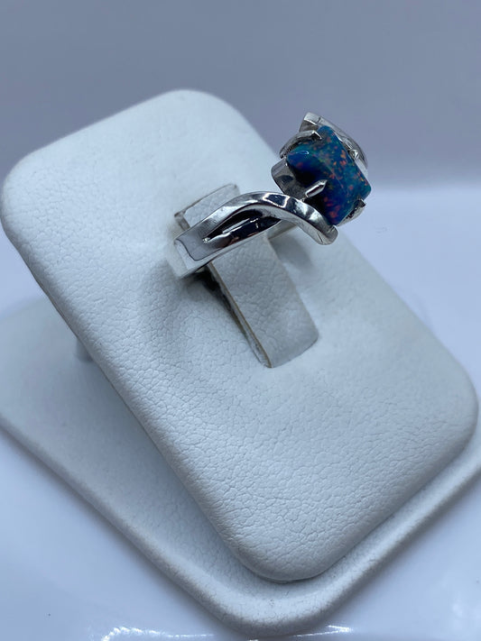 Detalle del ópalo azul con fuego rojo en engaste de plata pulida